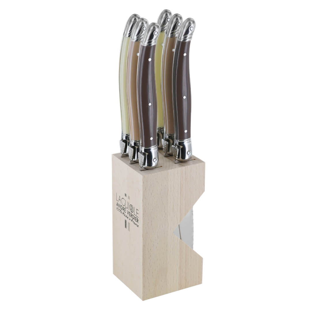 A 6-piece steak knife set in a light natural wood block, featuring dark brown and beige handles with silver bolsters, on a white background.