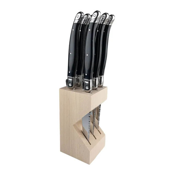 Set of knives with black handles in a wooden block on a white background